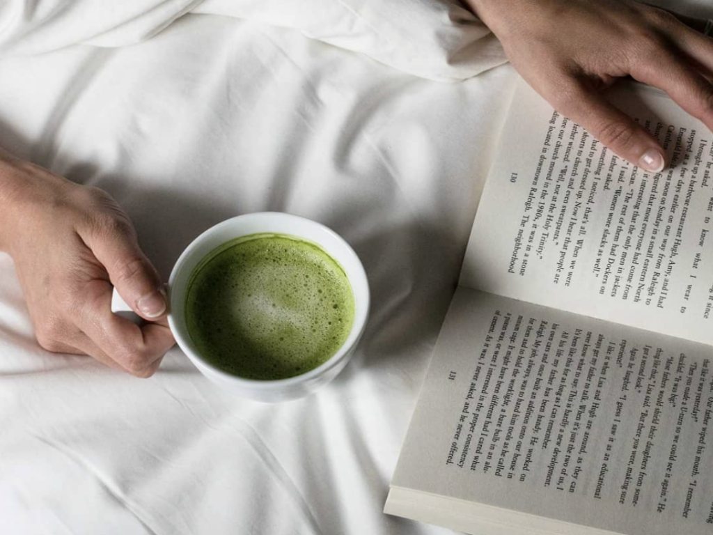 Reading a book and drinking matcha latte